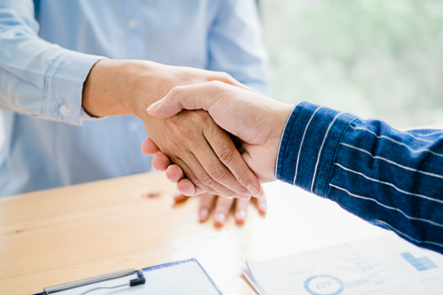 Partner Detailaufnahme zweier Personen die sich die Hand reichen