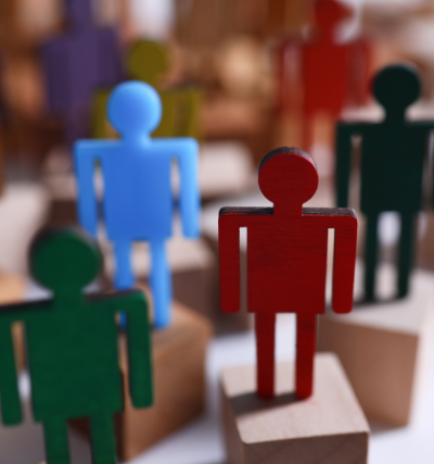 Eine Gruppe von bunten Holzfiguren steht auf Klötzen